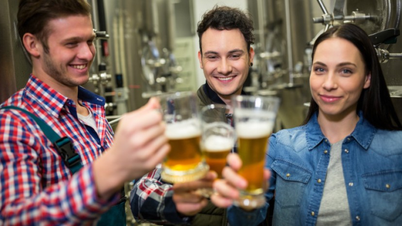 Personengruppe mit Bierkrügen in Brauerei