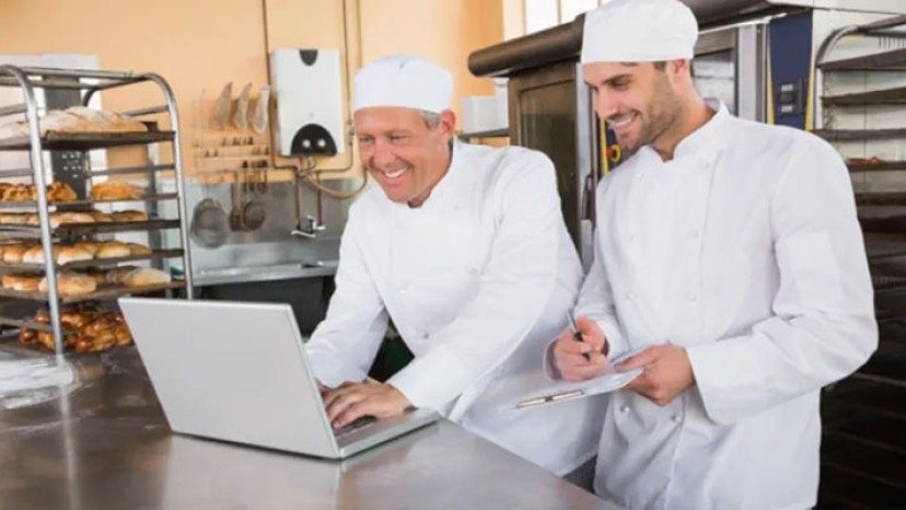 zwei Bäcker mit einem Laptop