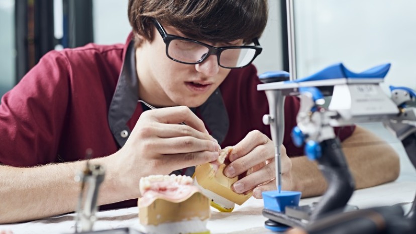Auszubildender arbeitet an einer Zahnprothese