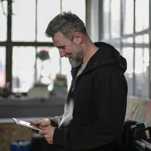 Mann blickt auf Tablet in seinen Händen