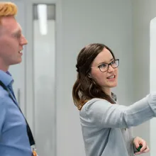 Mann und Frau in Büro vor Tafel