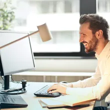 Mann lachend am Schreibtisch