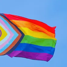 Einen Regenbogenflagge weht an einem Fahnenmast.