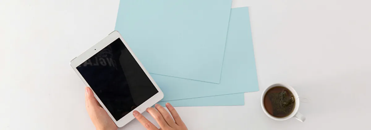 Kaffetassen, Blätter und Tablet auf Schreibtsich