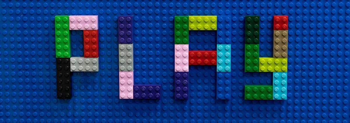 Das Wort Play mit Klemmsteinen gelegt