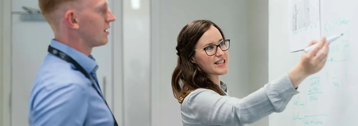 Mann und Frau in Büro vor Tafel