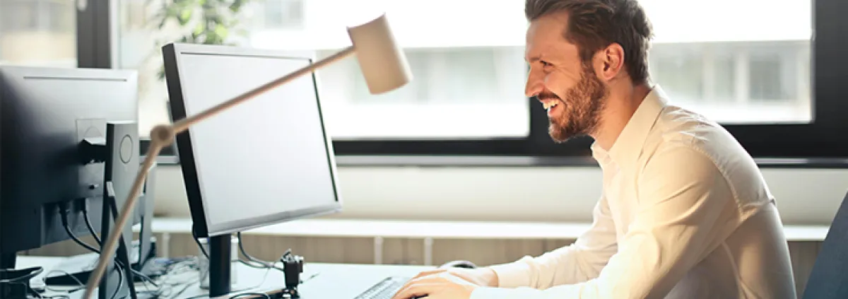 Mann lachend am Schreibtisch