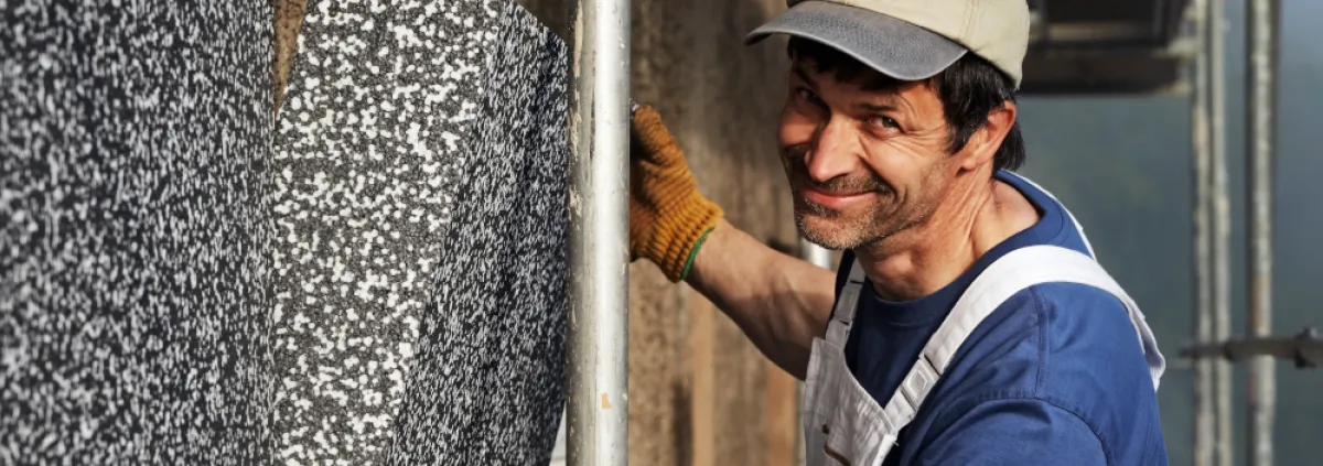Handwerker bringt Wanddämmung an