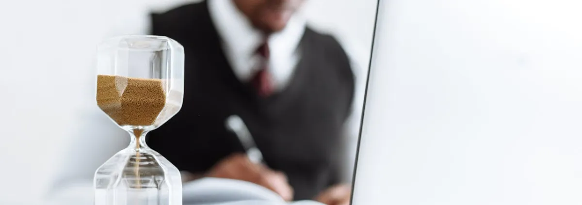 Mann an Bürotisch mit Sanduhr