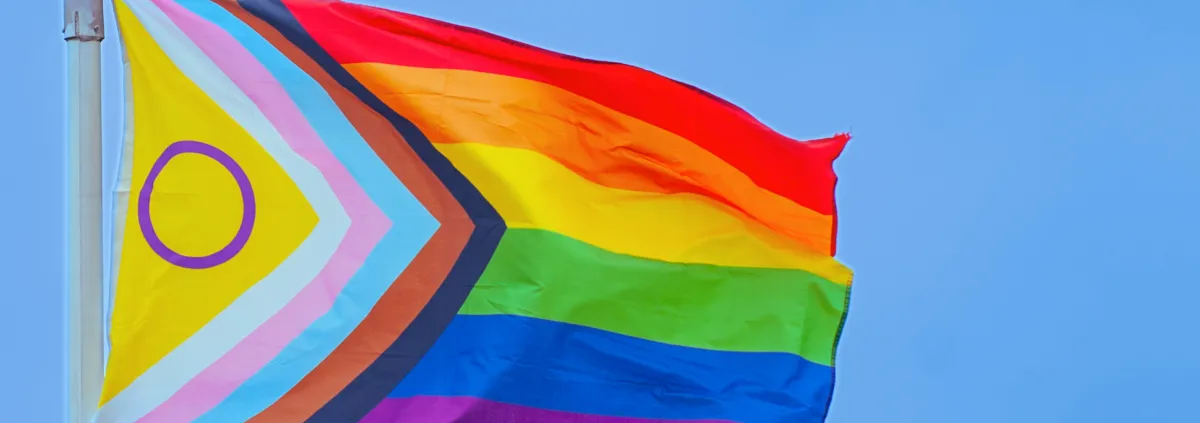 Einen Regenbogenflagge weht an einem Fahnenmast.