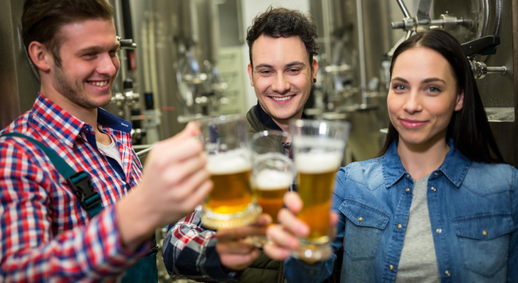 Personengruppe mit Bierkrügen in Brauerei